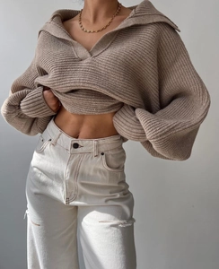 Nahaufnahme eines braunen Oversize-Strickpullovers mit breitem Revers und Rippenstruktur