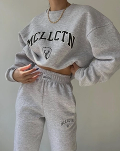 Detail of the gray tracksuit showing waist label and MCLLCTN logo print on cotton fabric