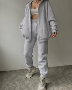 Detail view of gray fleece-lined hoodie and drawstring sweatpants with MALLEST brand tag