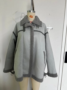 Detail view of grey faux shearling jacket featuring buckled collar and metal zipper closure