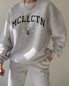 Detail of grey fleece sweatsuit featuring collegiate print and relaxed fit joggers