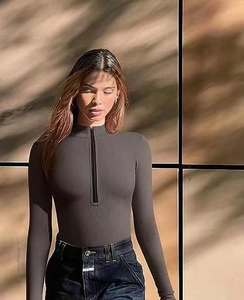 Close-up of grey ribbed knit long sleeve bodysuit with half-zip mock neck detail