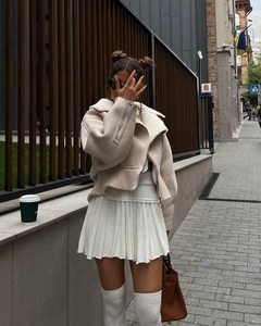 Detail of a beige faux suede biker jacket with white faux fur collar and street style look