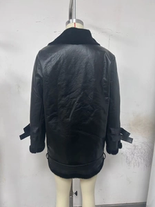 Détail arrière d'une veste en daim noir et peau lainée avec boucles aux poignets