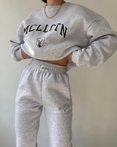 Detail of grey fleece sweatsuit featuring black MCLLCTN graphic print and elastic waist