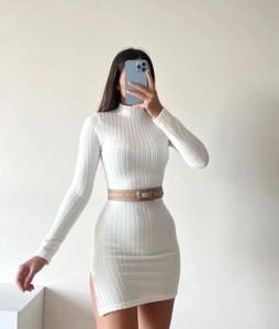 Détail d'une mini-robe en maille blanche avec fente latérale et ceinture en cuir