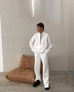 Detail view of white fleece tracksuit featuring side slits on wide-leg pants and cozy fabric