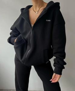 Detail of black oversized MAI STUDIOS CO. fleece hoodie set with white printed logo