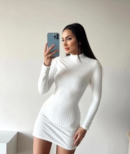 Détail de la texture en maille côtelée blanche sur une mini-robe ajustée à manches longues