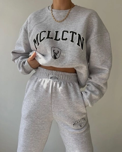 Detail of grey fleece tracksuit set with MCLLCTN collegiate lettering and logo prints