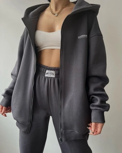 Detail of dark grey zip-up hoodie set with MAI STUDIOS CO embroidery and ribbed waistband
