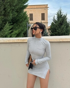 Detail view of the elegant grey ribbed knit texture and side slit on this slim dress