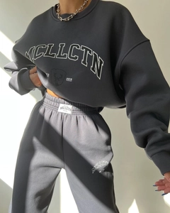 Close-up of white MCLLCTN graphic print on charcoal grey fleece sweatshirt set
