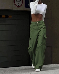 Detail of high-waisted dark green cargo pants featuring large side pockets on female model