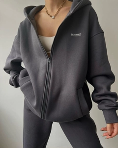 Detail of dark grey fleece hoodie set with white MAI STUDIOS CO. text and soft fabric