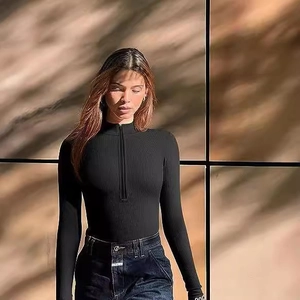 Slim fit black ribbed bodysuit for women with front zipper and long sleeves on model