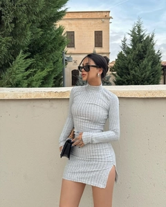 Close-up of grey ribbed knit dress featuring a turtleneck design and subtle side slit detail