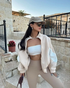 Close-up of beige stand-collar jacket with curved patchwork and high-waist ribbed leggings