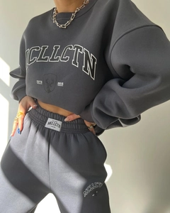 Detail of dark grey fleece tracksuit featuring white MCLLCTN letter print and heavy cotton texture