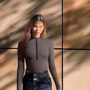 Women's dark grey ribbed long sleeve bodysuit with half-zip stand collar and sleek fit