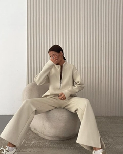 Detail view of cream lounge set featuring a half-zip pullover and split hem wide-leg pants