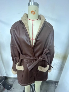 Detail of winter coat featuring faux fur trimming on collar and cuffs with waist tie belt