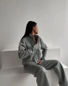 Detail of grey fleece-lined women's two-piece set with half-zip sweatshirt and trousers