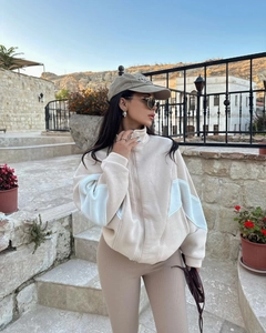 Detail of cream high-neck jacket with blue sleeve panels and casual street style look