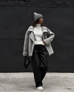 Close-up of a shearling aviator jacket with oversized lapels and metal buckle details