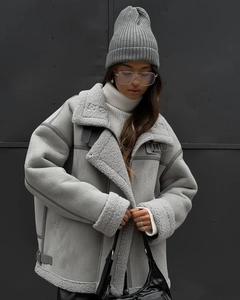 Detail of light gray lamb wool jacket featuring plush lapels and metal buckle adjustment