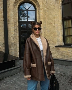 Detail of faux shearling trim on oversized dark brown leather jacket for women