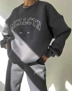 Detail of dark grey tracksuit with MCLLCTN letter print and graphic deer head logo