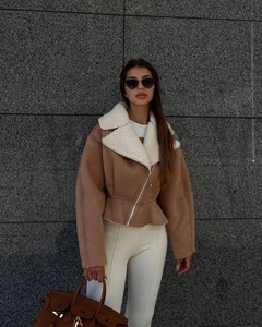 Detail of camel faux suede jacket featuring a wide white shearling lapel and diagonal zipper