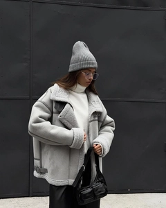 Detail of grey shearling aviator jacket featuring suede texture and white faux fur collar