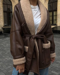 Detail of dark brown faux leather coat with beige shearling cuffs and large pockets