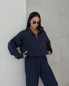 Detail of navy blue tracksuit showing half-zip collar and premium knit texture