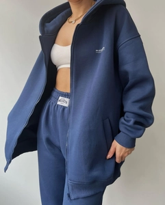 Detail shot of navy oversized hoodie fabric texture with embroidered brand logo
