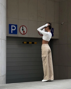 Detail of high-waisted beige cargo pants and white long-sleeved crop top set for women