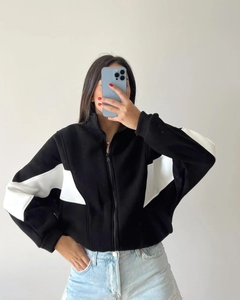 Close-up of black and white color-blocked zip-up sweatshirt with a stand-up collar