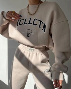 Detail of beige fleece tracksuit with vintage graphic print and elastic cuffs