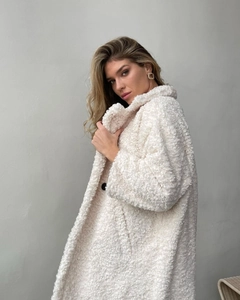 Detailansicht der cremeweißen Teddyjacke mit großem Revers und schwarzen Knöpfen