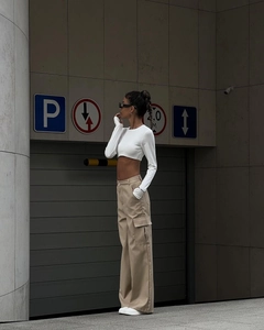 Outdoor street shot of women's khaki high-waisted cargo pants with side flap pockets