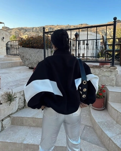 Back view of a casual loose color-block jacket with white V-shaped stitching detail