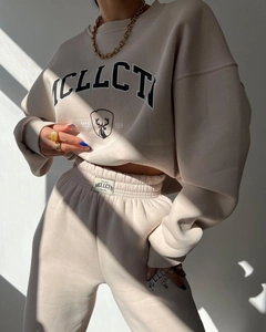 Detail of beige fleece sweatsuit set featuring MCLLCTN graphic and drawstring waistband