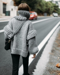 Vue arrière d'un pull gris à col roulé en maille épaisse avec des manches à volants