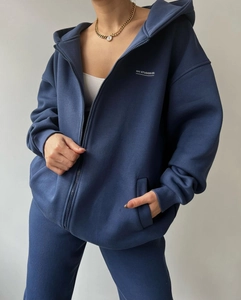 Detail of navy blue oversized zip-up hoodie set featuring white MAI STUDIOS CO print