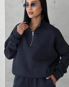 Detail of navy half-zip sweatshirt with stand collar, dropped shoulders and ribbed cuffs