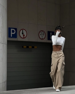 Outdoor street style shot of khaki wide-leg cargo pants paired with a white crop top