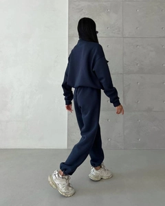 Rear view of women's dark blue thick tracksuit set with hoodie and joggers