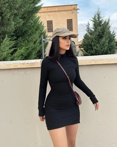 Close-up of black ribbed knit fabric texture on a slim-fit turtleneck mini dress